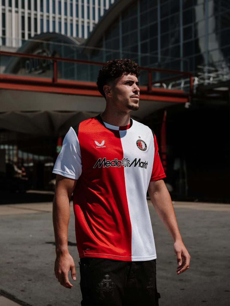 Een model draagt het thuisshirt van Feyenoord voor 2026-2027, gefotografeerd in een stedelijke omgeving