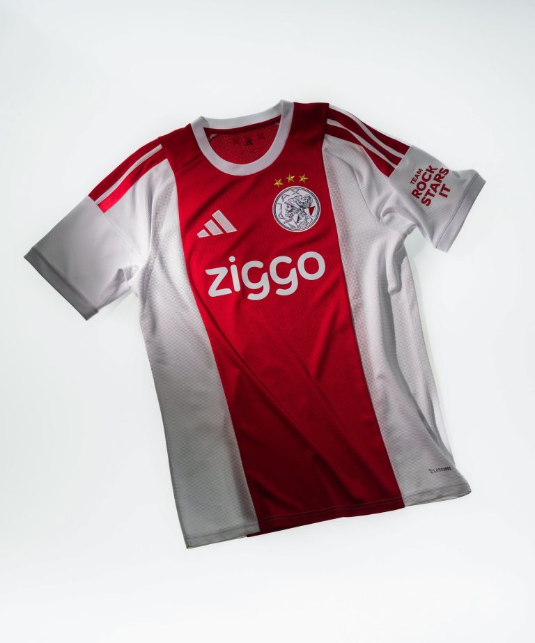 Het rood-witte thuisshirt van Ajax voor het seizoen 2026-2027, plat gefotografeerd met de sponsor Ziggo op de borst