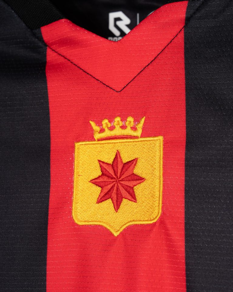 Detailopname van het clublogo en de kraag van het thuisshirt van Excelsior voor 2026-2027