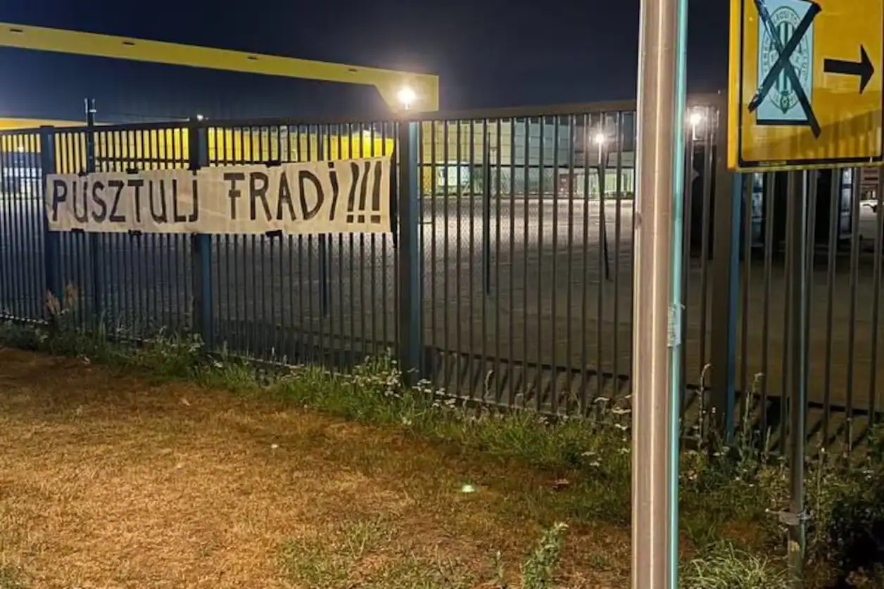 Wit spandoek met de Hongaarse tekst Pusztulj Fradi aan een hek in Enschede